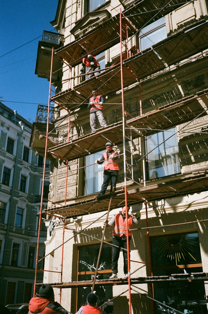Trabajadores en construcción sobre andamios alquilados